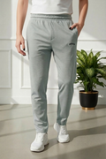 Person wearing light gray jogger pants with a plant in the background