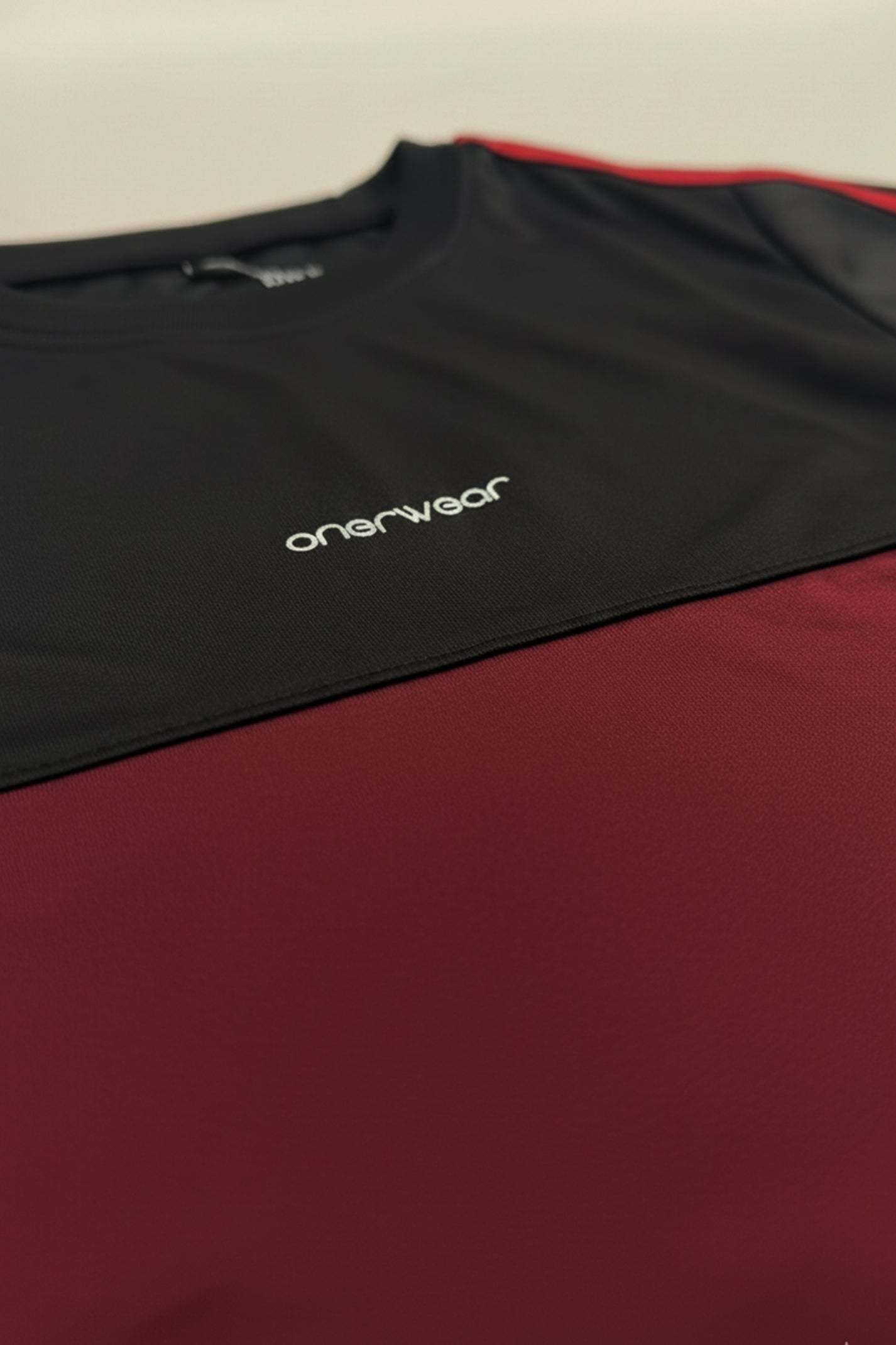 Black and red shirt with 'onerwear' logo on a beige background