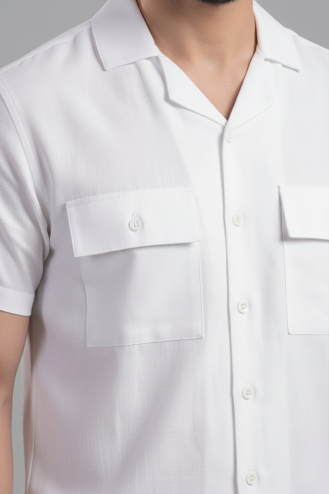 Man wearing a white outfit with sunglasses on a gray background