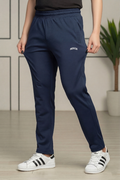 Person wearing navy blue jogger pants with a brand logo and white sneakers indoors.