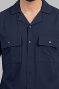 Navy blue shirt with two front pockets on a gray background