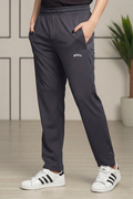 Person wearing dark gray sweatpants with a brand logo and white sneakers indoors.