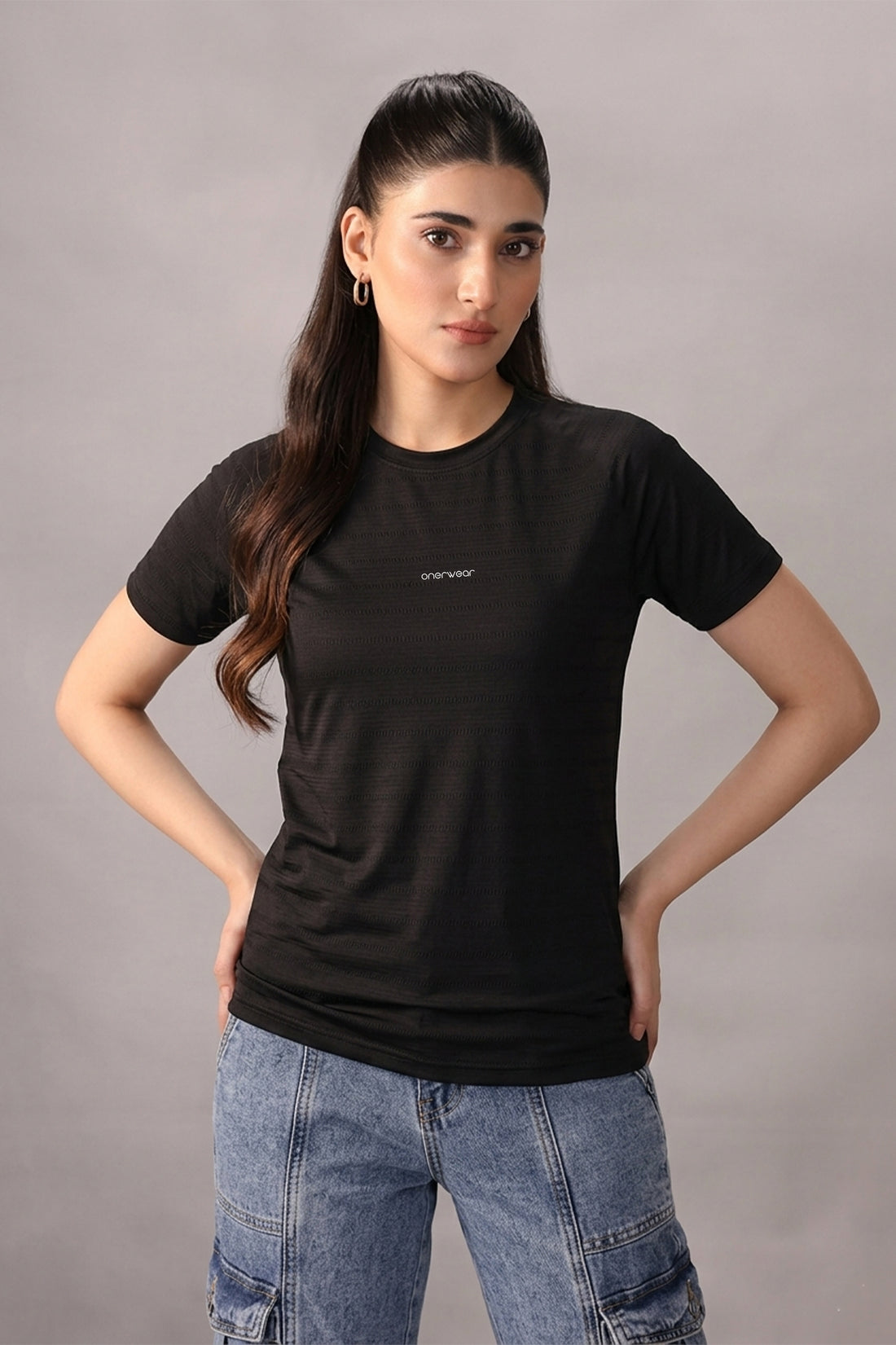 Woman wearing a black t-shirt with text on a gray background
