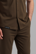 Brown shirt and pants with a visible brand label on a gray background