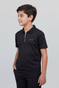 Child wearing a black polo shirt with a logo on a light gray background