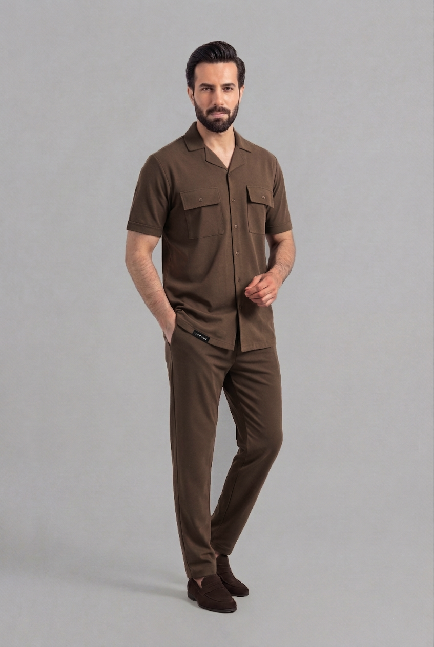 Man wearing a brown shirt and pants on a gray background