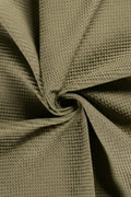Close-up of textured green fabric with a crumpled appearance