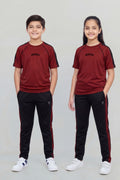 Two children wearing matching red and black outfits on a plain background