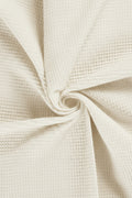 Close-up of beige textured fabric with a swirl pattern