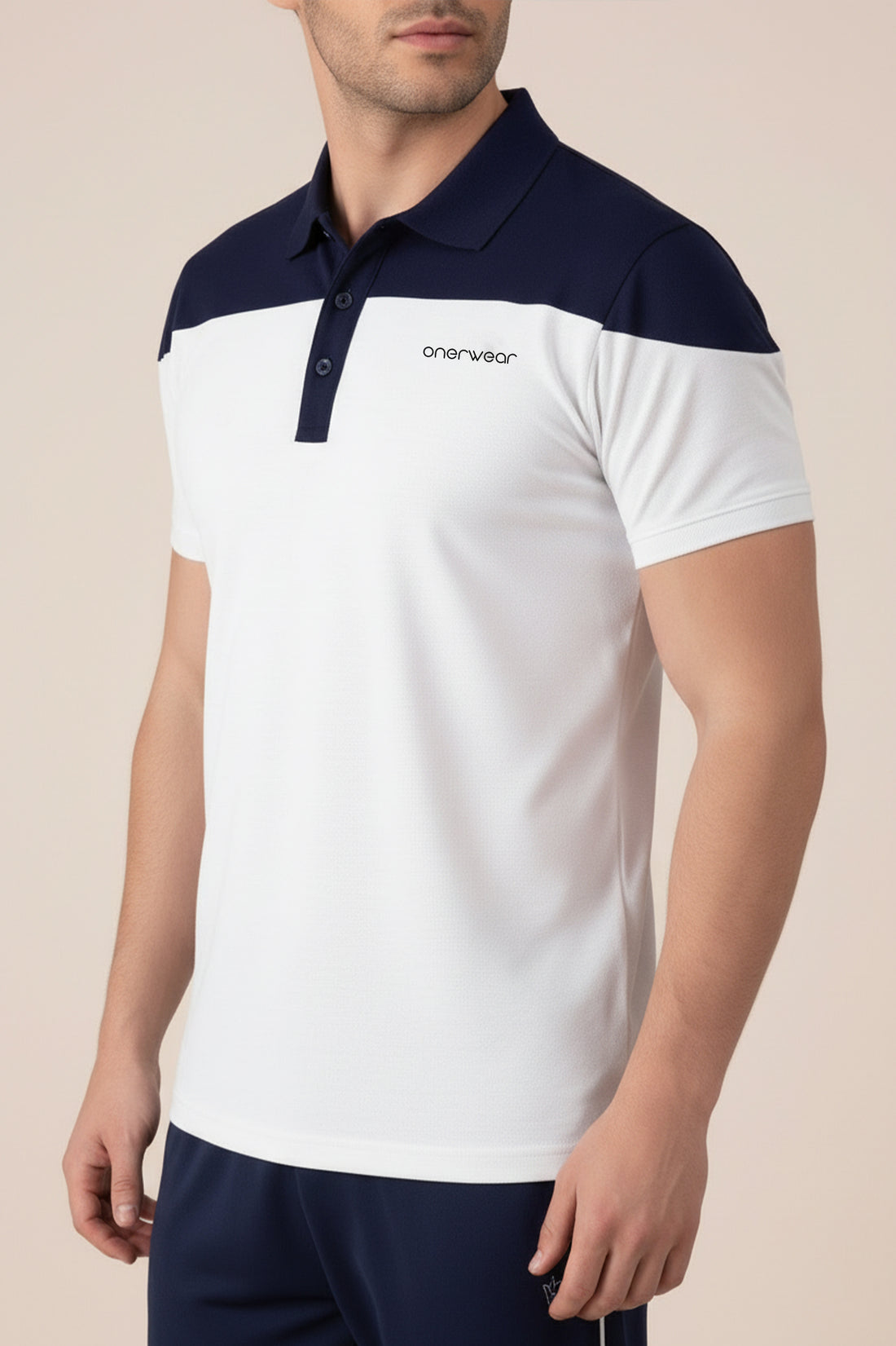 Man wearing a white and navy polo shirt with a visible brand logo on a beige background