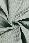 Close-up of textured green fabric with a crumpled appearance