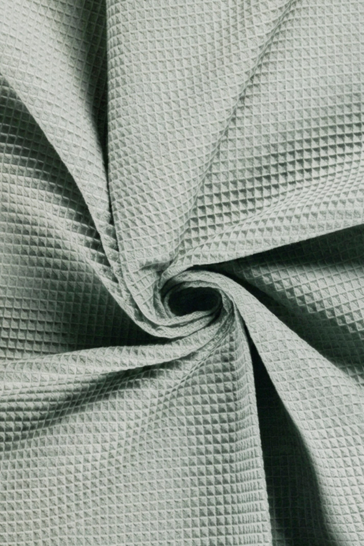 Close-up of textured green fabric with a crumpled appearance