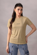 Woman wearing a beige t-shirt with a logo on a gray background