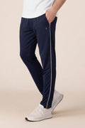 Person wearing navy pants with a white stripe on a beige background